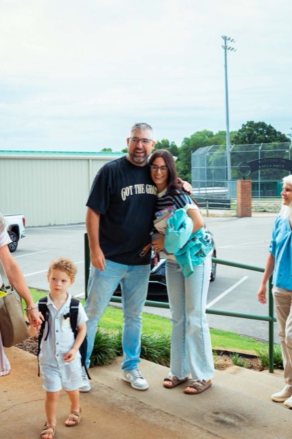 A family walking in together, one child carrying a backpack