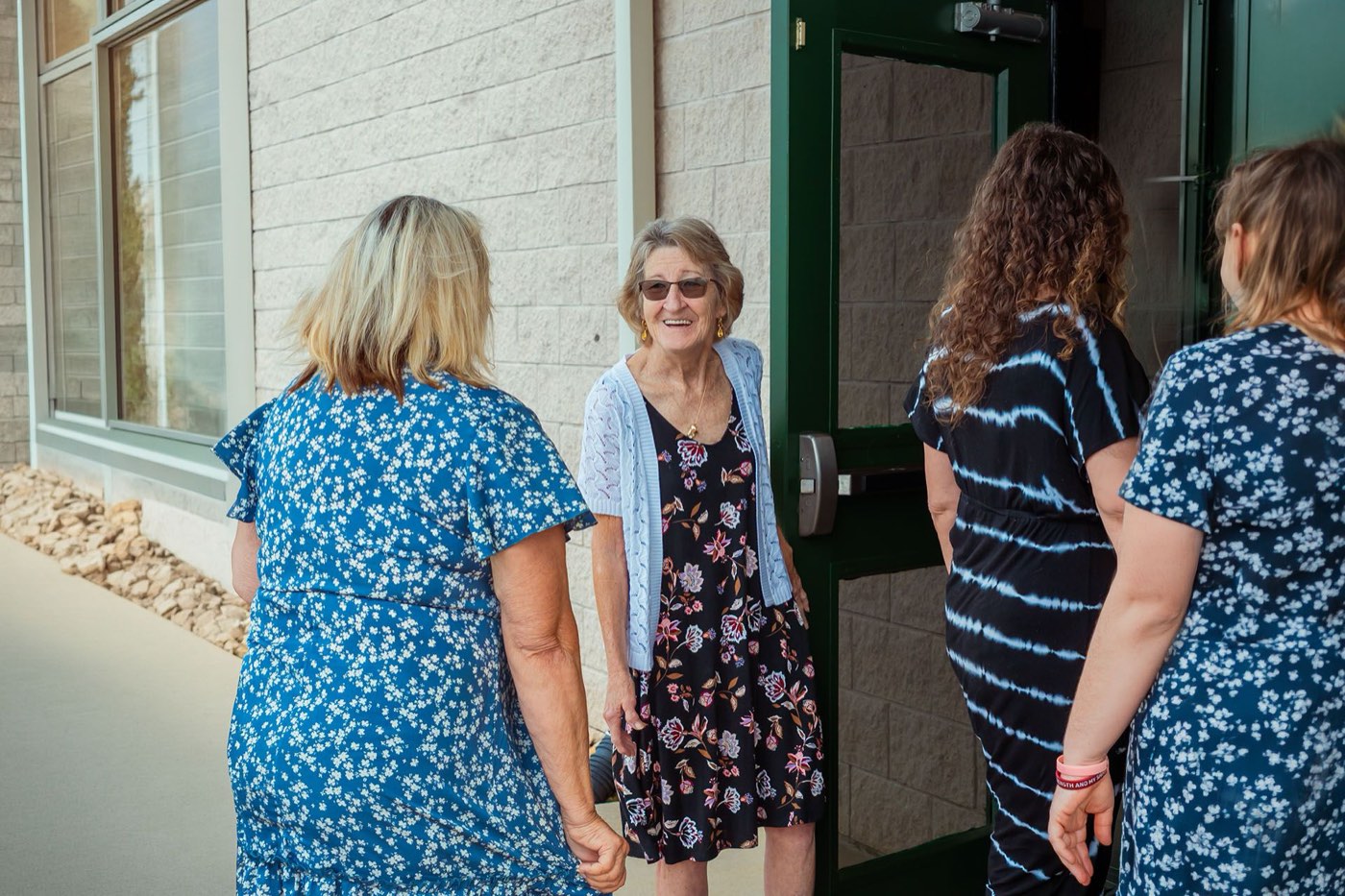 A greeter smiling at the door as people arrive
