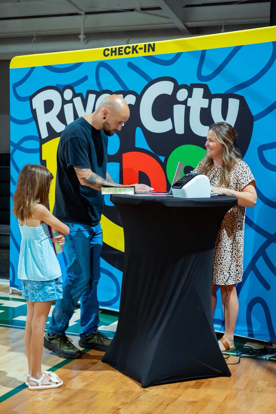 Families checking in at the River City Kids desk